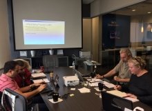 4 students at a conference table working on an in class SEO project