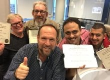 Four happy students with their SEO Certification Diplomas pose for a fun selfie with Greg